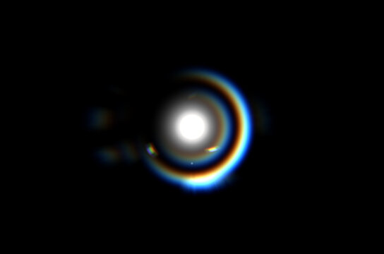 Real lens flare light effect with rainbow prism refraction and bokeh glow on black background