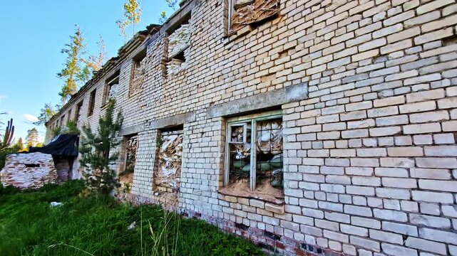 Old abandoned brick building with broken windows reinforced with sandbags for protection