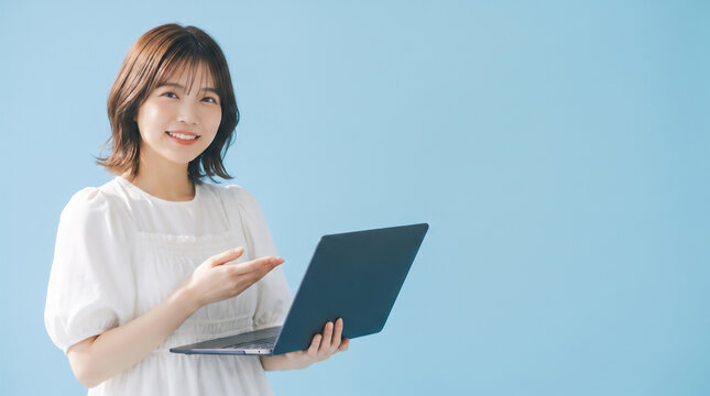 Smiling young Asian woman holding a laptop computer and presenting