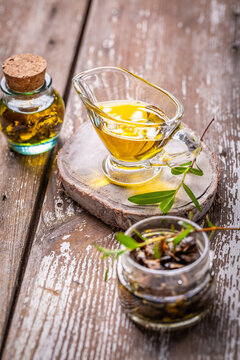 Truffle oil infused with herbs and mushrooms in glass jars on rustic wood