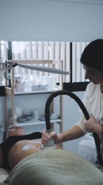 Aesthetic Specialist Administering Radiofrequency and Cryotherapy Body Contouring in Clinical Treatment Room