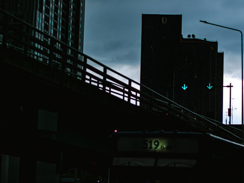 Silhouette of Elevated Highway Bridge Against Dusk Sky with City Skyscrapers, Urban Cityscape at Twilight