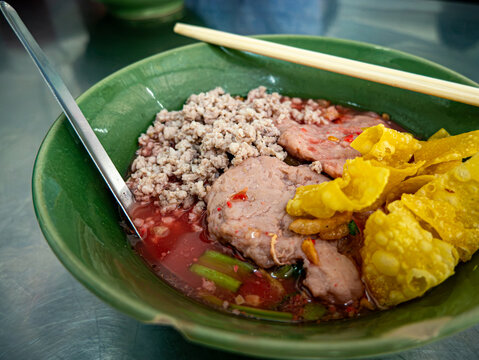 Thai Boat Noodle Soup Bowl with Minced Pork, Meatball, Crispy Wonton and Chopsticks Street Food Bangkok
