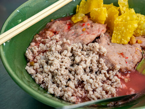 Thai Boat Noodle Soup Bowl with Minced Pork, Meatball, Crispy Wonton and Chopsticks Street Food Bangkok