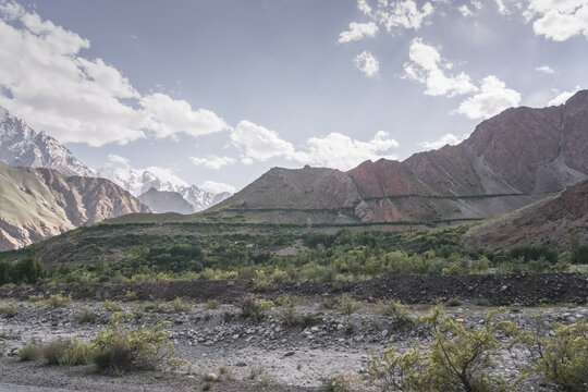 Mountain landscape in the Pamir Mountains of Tajikistan, with rocky slopes and green vegetation, in sunny weather in the Tien Shan Mountains