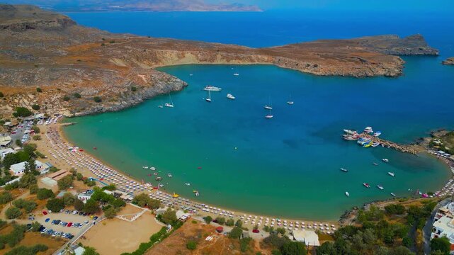 Scenic aerial drone view of St Paul bay beach with sunbed boats and rocky hill