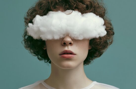 Young person with curly hair and a white cloud covering eyes against a teal