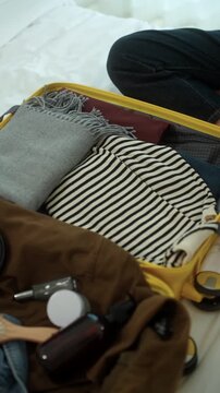 Young woman packing clothes into a suitcase for an upcoming trip at home. Travel preparation, vacation planning. Organized luggage, minimalist packing. Smart travel lifestyle.
