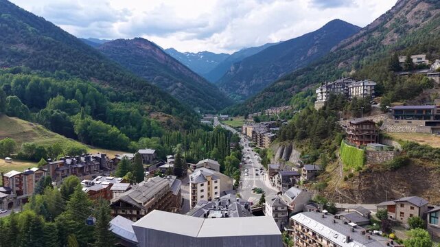 La Massana town in Andorra nestled in a Pyrenean valley, surrounded by forested mountains, with buildings lining a main road stretching into the distance