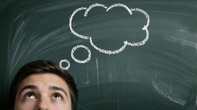 Young man looks up at chalk drawn thought bubble on chalkboard. Person contemplates idea, imagines future. Conceptual symbol for brainstorming.
