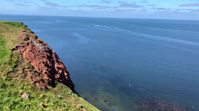 Stationary viewpoint overlooking sea currents below island cliffs