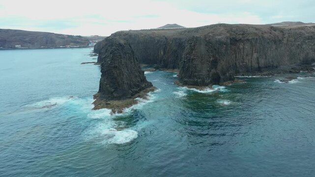 Majestic aerial perspective showing the stunning Roque del Farallon, a volcanic sea stack, and the rugged cliffs of Gran Canaria's coast