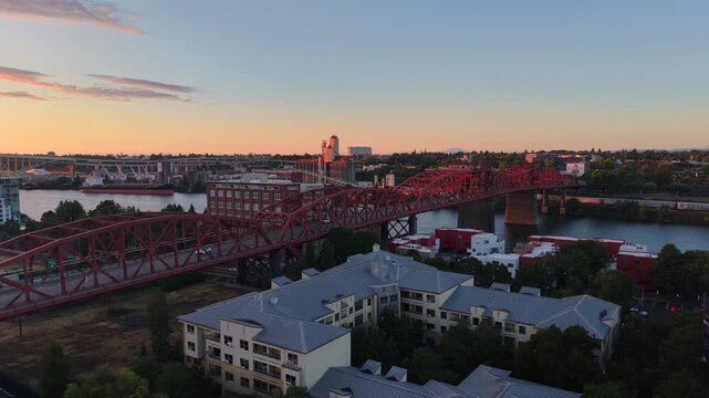 Red Broadway Bridge over Willamette River at sunset in Portland