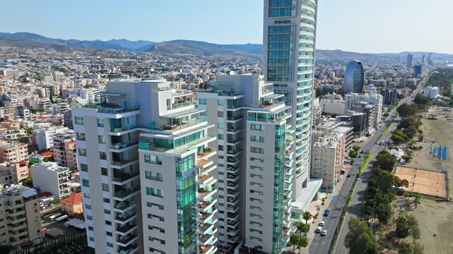 Aerial view of Limassol seafront district in Cyprus. Tall buildings, city streets and nearby Mediterranean coastline create a modern coastal panorama.