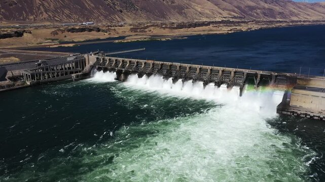 4K aerial drone footage of John Day Dam near Rufus, Oregon, USA. Hydroelectric power station, renewable energy, pelicans fishing below the spillway in the Columbia River Gorge