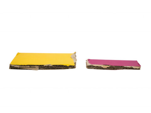 Two pieces of yellow and magenta corrugated cardboard isolated on transparent background for packaging design concepts