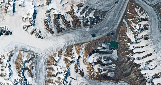 Aerial shot of glaciers covered with snow in mountainous area. Camera is moving left and up. Animation based on image by NASA