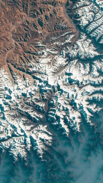 Flying above fog, snowy mountains and desert. Camera is moving forward. Vertical video. Animation based on image by NASA