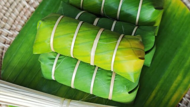 Khao Tom Mud before cooking,Traditional Thai dessert sticky rice, coconut milk and banana wrapped and black beans in banana leaves