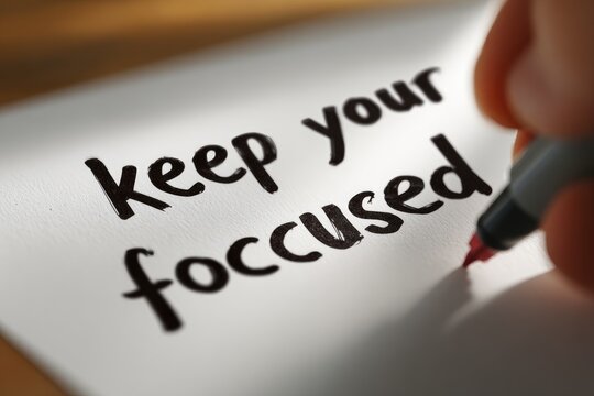 Hand writing "Keep your focused" on white paper