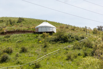 Obraz premium White yurt rests on grassy hillside