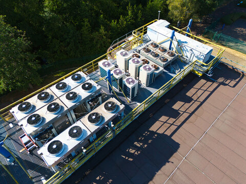 Aerial view of data center HVAC thermal management and cooling fans on a rooftop, featuring industrial air conditioning units with yellow railings in Andover, England, United Kingdom.