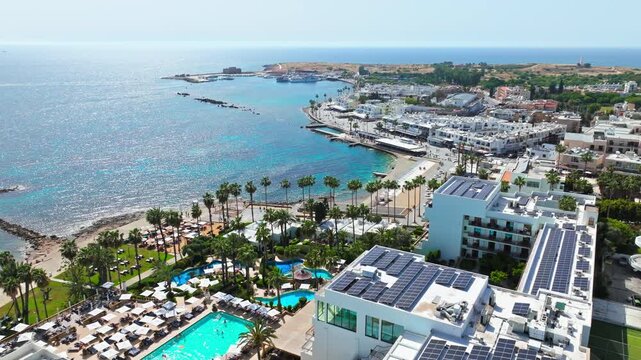Aerial view of Paphos waterfront and harbour area in Cyprus. Hotels, promenade, marina coastline and calm sea create a bright Mediterranean cityscape.