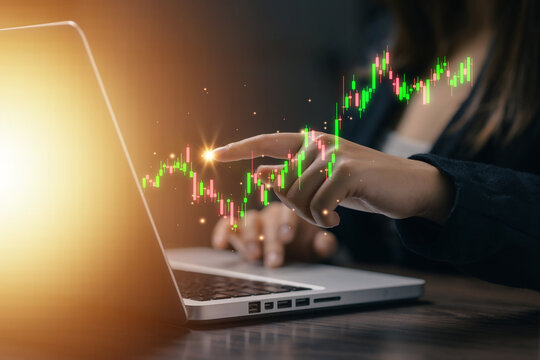 Businesswoman analyzing financial market trends on laptop with candlestick chart, stock investment, trading strategy, business analytics and digital finance technology concept.