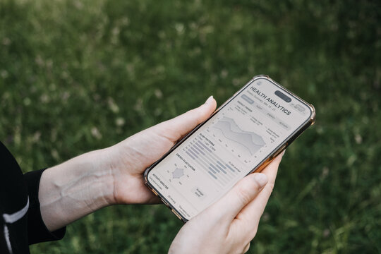Hands hold smartphone displaying health analytics application with sleep metrics outdoors. Sleep tracking app, sleeping pattern analysis, Sleep quality dashboard