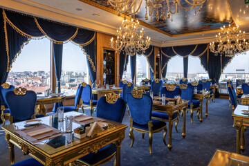 Fototapeta premium Luxury rooftop restaurant interior with city view and blue velvet seating
