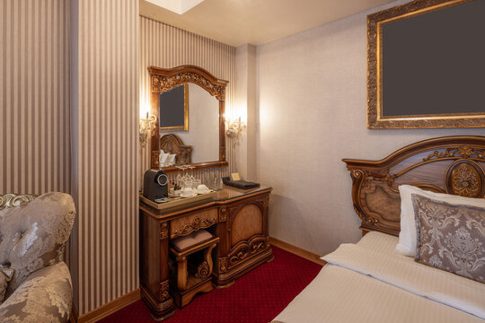 Classic luxury hotel bedroom corner with ornate carved wooden bed and desk