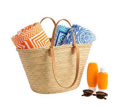 Woven straw beach bag with colorful towels, sunscreen bottles, and sunglasses isolated on transparent background