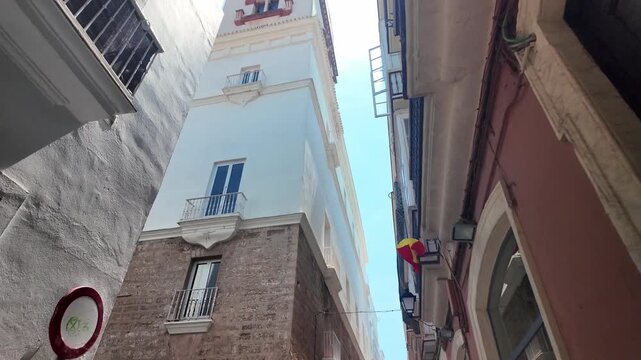 Low angle view of Torre Tavira watchtower from narrow street, Cadiz, Spain