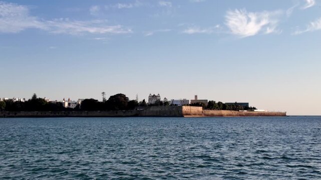 Boat approach to Baluarte de la Candelaria at sunset, Cadiz, Spain