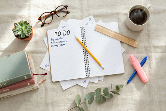 Top view of to do list in spiral notebook with pencil glasses and coffee, notebook