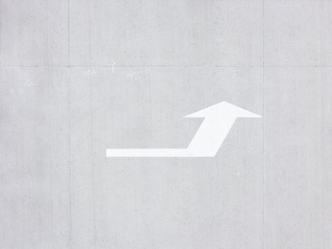 Aerial view of a white directional arrow painted on a grey concrete surface in Kaunas, Kaunas County, Lithuania.