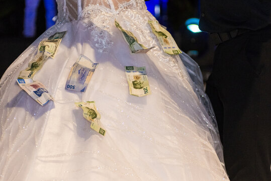 Bride Wearing Wedding Dress Covered With Mexican Peso Bills During Traditional Money Dance