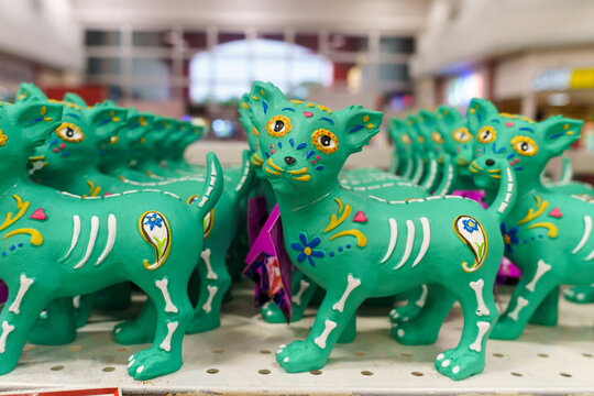 Green Ceramic Dog Figurines With Day of the Dead Skull Designs on Display Shelf