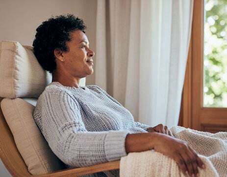 Mujer mayor descansando en un sill&oacute;n c&oacute;modo y manta suave. Rutina de descanso y confort