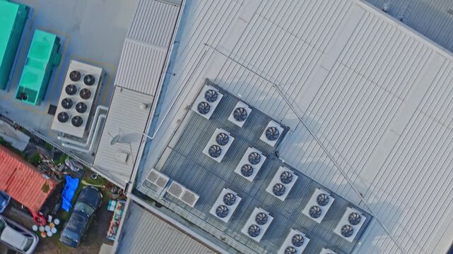 Drone shot of a data center rooftop showcasing industrial cooling units, ventilators, and geometric metal architecture in crisp daylight. Clean, technical composition, no people present.