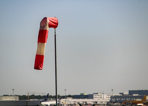 Airport windsock showing wind direction above airfield on a sunny day in Frankfurt, Germany