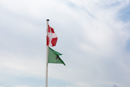Denmark flag and green safety flag flying