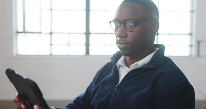 Businessman, tablet and reading in office with glasses, review architecture and research for project. Architect, black person and spectacles in workplace with tech, planning or check building design.