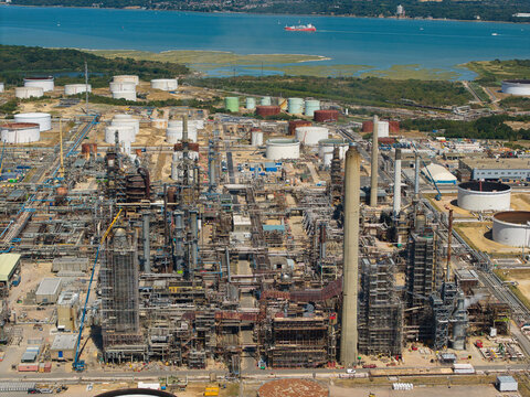Aerial view of the Fawley Refinery, a massive petroleum chemical manufacturing plant with storage tanks, pipe networks, and tall chimneys, Southampton, England, United Kingdom.