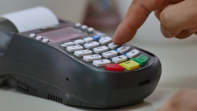 Mans hand pushing the button and swipe credit card on electronic terminal standing in modern shopping mall for consumer retail payment in 4K Ultra HD footage
