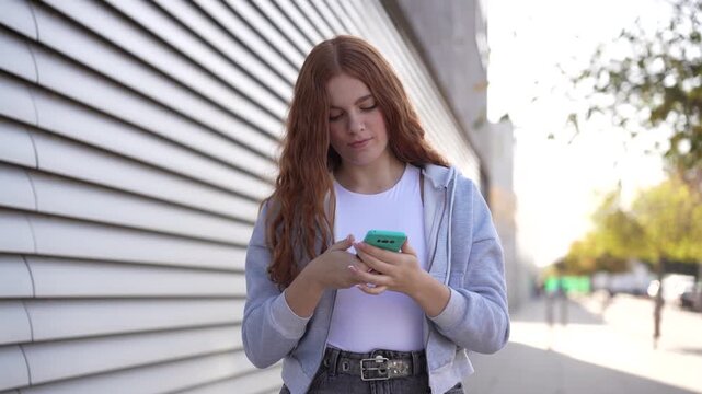 A young woman is texting on her smartphone while enjoying the outdoors during the daytime