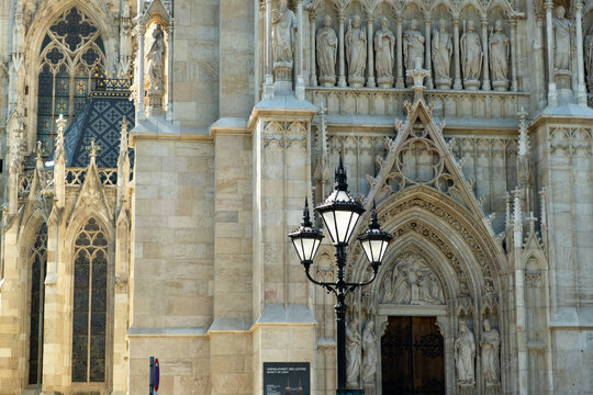 Ornate neogothic facade with statues and lantern at Votivkirche church