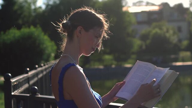 Young woman reading book in summer park. Digital detox in action. Intentional escape from screens. Brain reset through nature and words. Mindfulness among green trees. Book lovers day