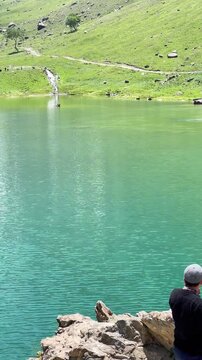 Man Standing by Minimarg Lake as Camera Reveals Scenic Mountain View
