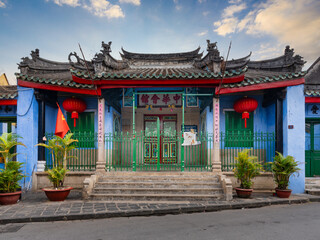 Obraz premium The historic Trung Hoa Assembly Hall in Hoi An, Vietnam, displaying vibrant Chinese architecture with red lanterns, green iron gates, and blue walls